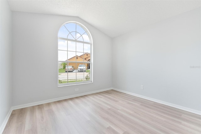 313 Cheshire Way, Davenport, FL 33897 - spare room with light wood-style floors, vaulted ceiling, and a textured ceiling