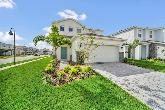 3448 Lilac Way, Davenport, FL 33897 - view of front of house featuring stone siding, a front yard, decorative driveway, and stucco siding