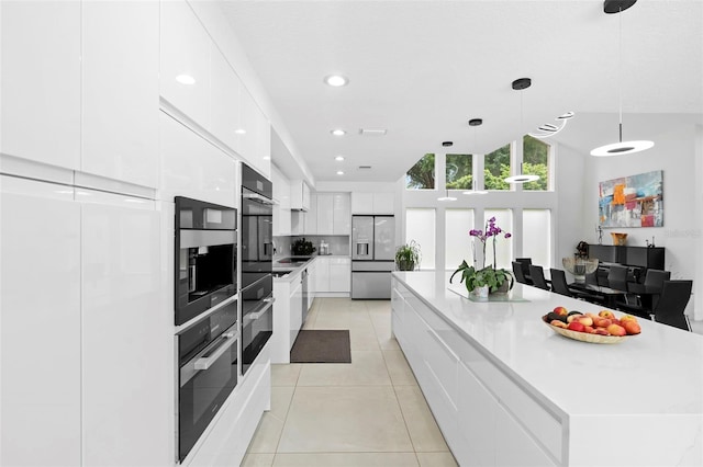 7905 Chad Ct, Orlando, FL 32835 - kitchen with stainless steel appliances, modern cabinets, white cabinets, light tile patterned floors, and a large island