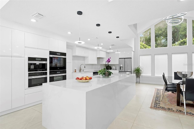 7905 Chad Ct, Orlando, FL 32835 - kitchen featuring stainless steel fridge, modern cabinets, white cabinets, light countertops, and light tile patterned floors