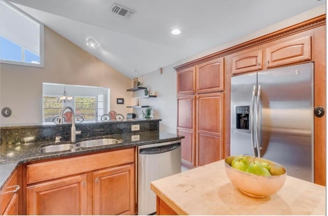 7905 Chad Ct, Orlando, FL 32835 - kitchen featuring stainless steel appliances, lofted ceiling, dark stone counters, brown cabinets, and recessed lighting