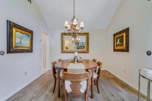 7905 Chad Ct, Orlando, FL 32835 - dining area with a chandelier, light wood-style floors, and vaulted ceiling
