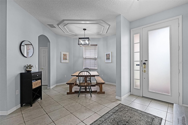 11337 Via Andiamo, Windermere, FL 34786 - dining space featuring a textured ceiling, light tile patterned flooring, arched walkways, and a raised ceiling