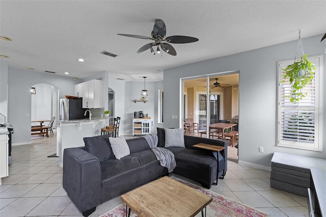 11337 Via Andiamo, Windermere, FL 34786 - living room featuring arched walkways, ceiling fan, light tile patterned floors, a textured ceiling, and recessed lighting