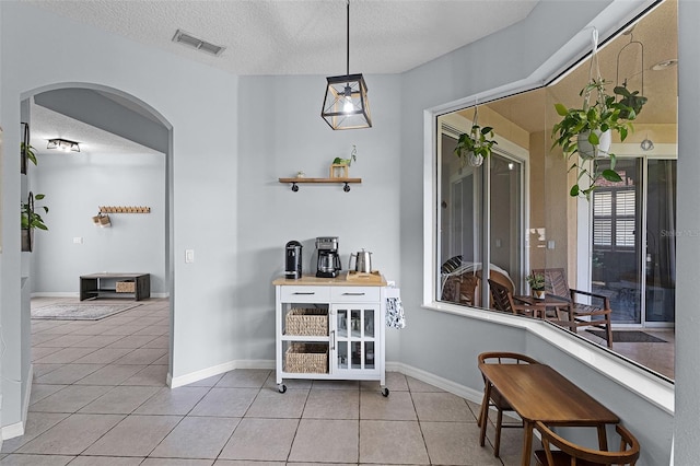 11337 Via Andiamo, Windermere, FL 34786 - dining area with a textured ceiling, light tile patterned floors, and arched walkways