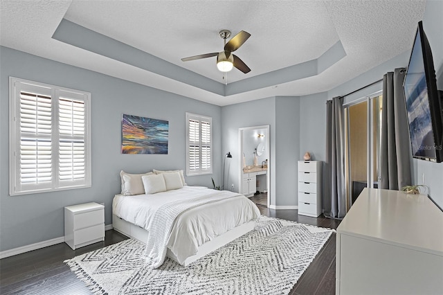 11337 Via Andiamo, Windermere, FL 34786 - bedroom with a tray ceiling, a textured ceiling, dark wood-style floors, a ceiling fan, and ensuite bath