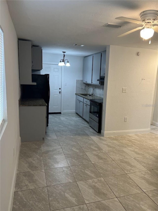 767 Willie Mays Pkwy, Orlando, FL 32811 - kitchen featuring electric range, dark countertops, ceiling fan, a chandelier, and freestanding refrigerator
