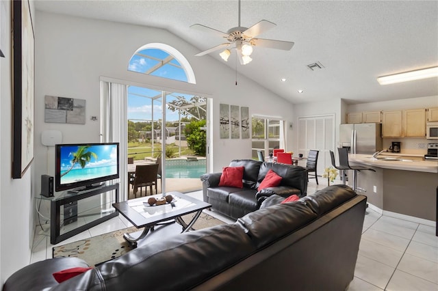 2979 Viscount Cir, Kissimmee, FL 34747 - living area with light tile patterned floors, a ceiling fan, a textured ceiling, and high vaulted ceiling