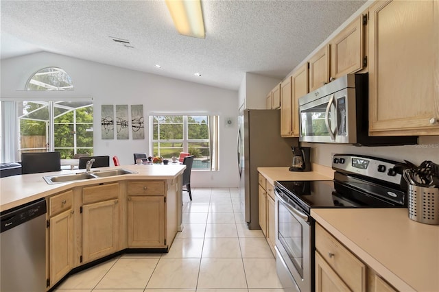 2979 Viscount Cir, Kissimmee, FL 34747 - kitchen featuring stainless steel appliances, vaulted ceiling, healthy amount of natural light, light brown cabinets, and light countertops
