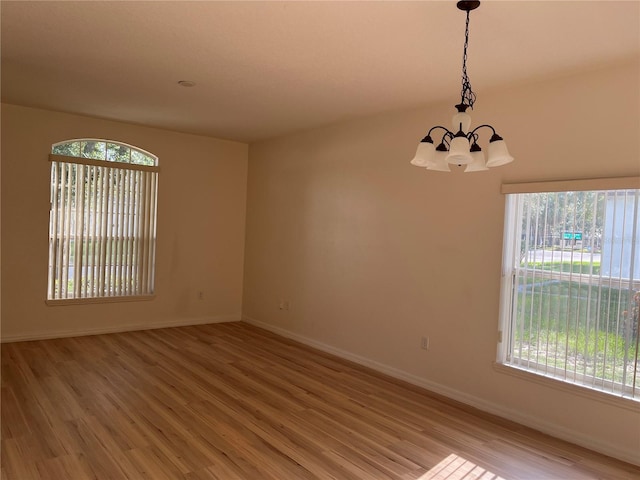 7714 Tanbier Dr, Orlando, FL 32818 - empty room featuring a chandelier and light wood-type flooring