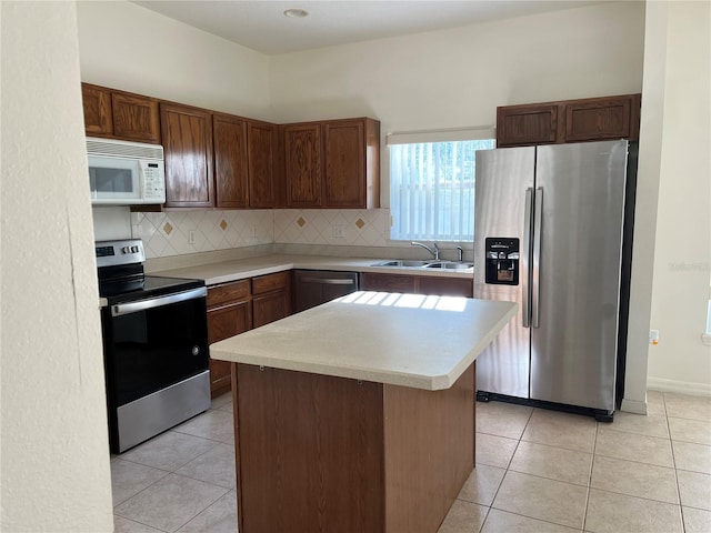 7714 Tanbier Dr, Orlando, FL 32818 - kitchen featuring appliances with stainless steel finishes, light countertops, backsplash, and a center island