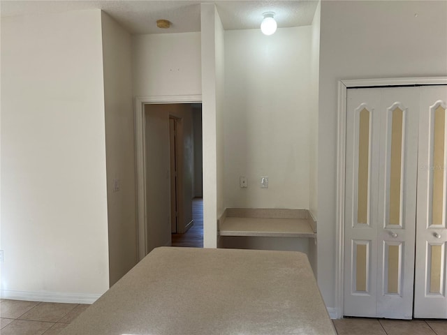 7714 Tanbier Dr, Orlando, FL 32818 - hallway featuring light tile patterned floors and baseboards
