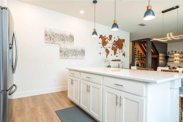 2813 Sanctuary Dr, Clermont, FL 34714 - kitchen with stainless steel fridge with ice dispenser, light wood-style floors, white cabinetry, decorative light fixtures, and light stone counters