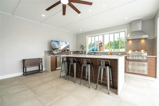 2813 Sanctuary Dr, Clermont, FL 34714 - kitchen with wall chimney range hood, light countertops, ceiling fan, a large island with sink, and modern cabinets