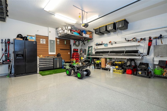 2813 Sanctuary Dr, Clermont, FL 34714 - garage with black fridge, a garage door opener, electric panel, and a workshop area