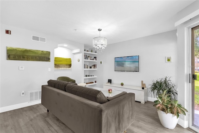 7350 Westpointe Blvd Unit 215, Orlando, FL 32835 - living area with light wood-style flooring, a chandelier, and built in features