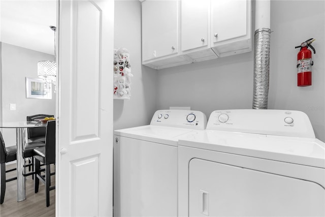 7350 Westpointe Blvd Unit 215, Orlando, FL 32835 - laundry area with cabinet space, washer and clothes dryer, and light wood-type flooring