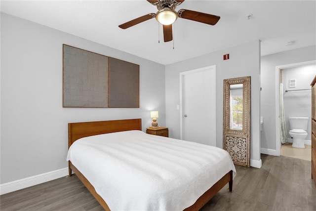 7350 Westpointe Blvd Unit 215, Orlando, FL 32835 - bedroom featuring wood finished floors, a ceiling fan, and connected bathroom