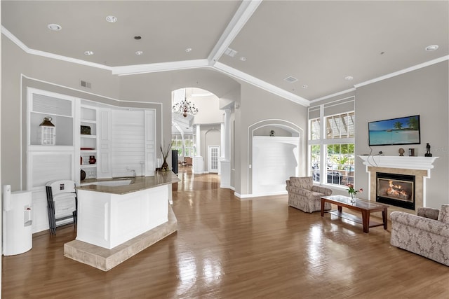 7350 Westpointe Blvd Unit 215, Orlando, FL 32835 - living area with arched walkways, a glass covered fireplace, wood finished floors, crown molding, and high vaulted ceiling