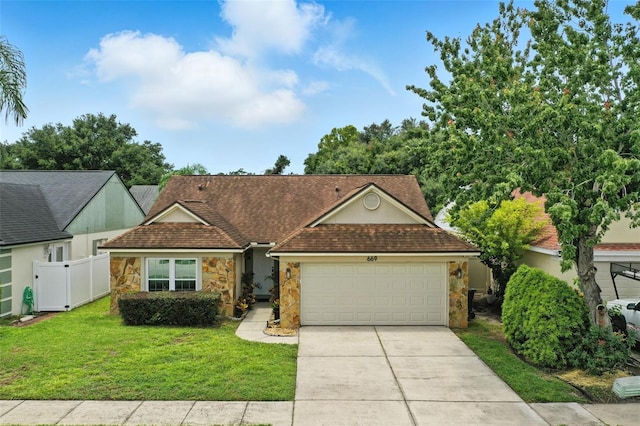 669 Whitetail Loop, Apopka, FL 32703 - view of front of home featuring stone siding, a garage, and driveway