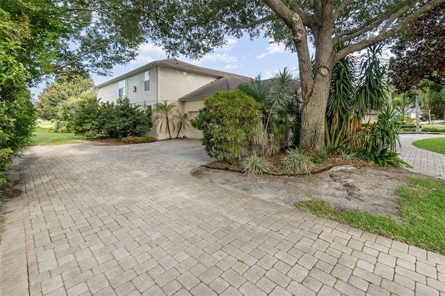 2317 Warren Woods Dr, Orlando, FL 32835 - view of side of property featuring stucco siding, decorative driveway, and an attached garage