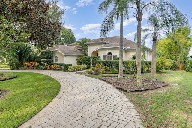 2317 Warren Woods Dr, Orlando, FL 32835 - view of front facade with stucco siding, curved driveway, and a front yard