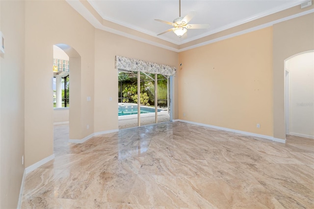 2317 Warren Woods Dr, Orlando, FL 32835 - empty room featuring arched walkways, healthy amount of natural light, ceiling fan, ornamental molding, and marble tiled floors