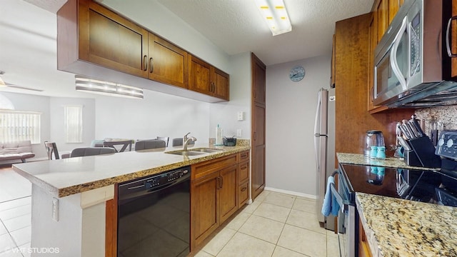 3151 Britannia Blvd Unit A, Kissimmee, FL 34747 - kitchen with stainless steel appliances, open floor plan, a peninsula, light tile patterned floors, and brown cabinetry