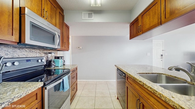 3151 Britannia Blvd Unit A, Kissimmee, FL 34747 - kitchen with electric stove, dishwashing machine, brown cabinetry, and light stone countertops
