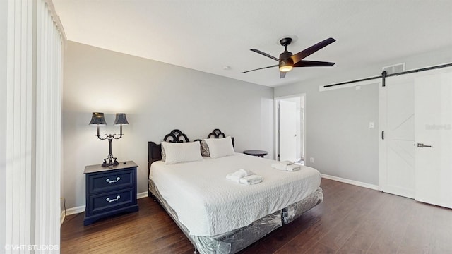 3151 Britannia Blvd Unit A, Kissimmee, FL 34747 - bedroom with a barn door, wood finished floors, and a ceiling fan