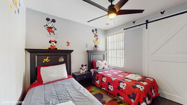3151 Britannia Blvd Unit A, Kissimmee, FL 34747 - bedroom with wood finished floors, a barn door, and a ceiling fan