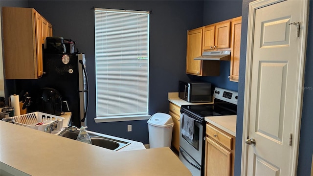 kitchen with electric stove, under cabinet range hood, light countertops, and freestanding refrigerator