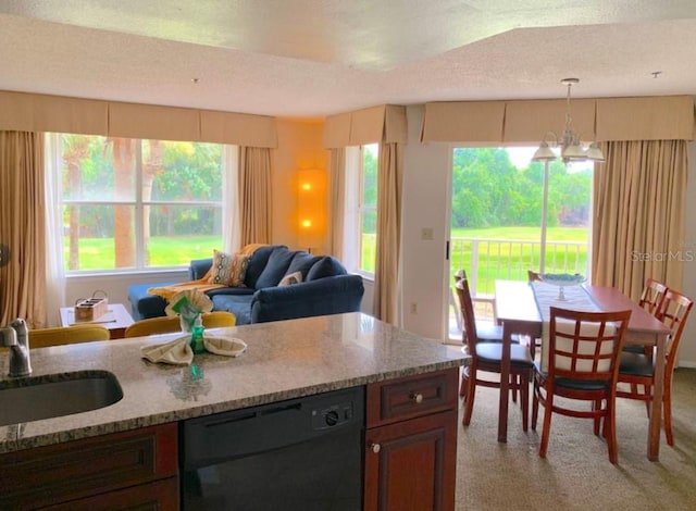 6336 Parc Corniche Dr, Orlando, FL 32821 - kitchen featuring dishwasher, light colored carpet, light stone counters, hanging light fixtures, and a textured ceiling