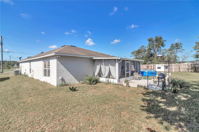 153 Juniper Run, Ocala, FL 34480 - back of house featuring a sunroom, a patio area, and stucco siding