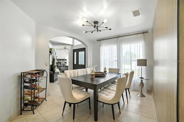 12419 Sion Ct, Orlando, FL 32824 - dining space featuring arched walkways, a chandelier, and light tile patterned floors