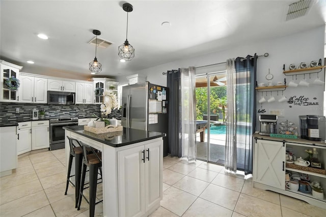 12419 Sion Ct, Orlando, FL 32824 - kitchen featuring appliances with stainless steel finishes, dark countertops, decorative backsplash, glass insert cabinets, and recessed lighting