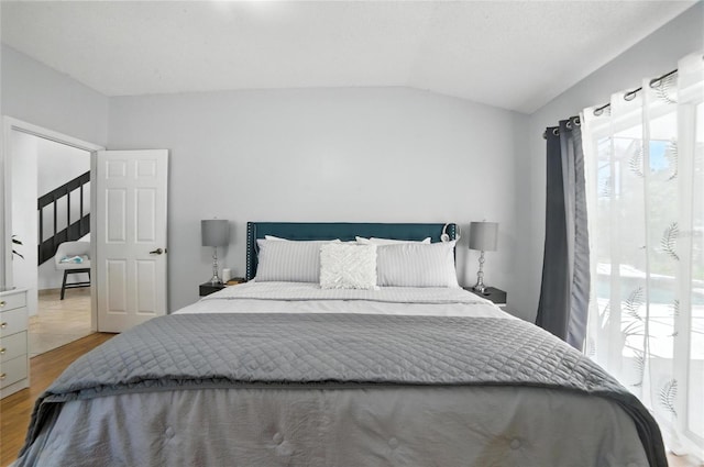 12419 Sion Ct, Orlando, FL 32824 - bedroom featuring multiple windows, lofted ceiling, and wood finished floors