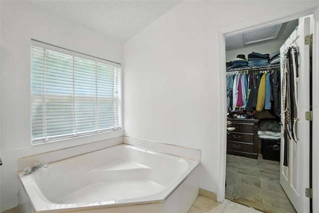 12419 Sion Ct, Orlando, FL 32824 - bathroom with a garden tub, a spacious closet, and tile patterned floors
