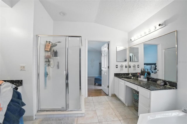 12419 Sion Ct, Orlando, FL 32824 - full bath with a shower stall, lofted ceiling, vanity, tile patterned flooring, and a textured ceiling