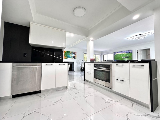 6258 Masters Blvd Unit C204, Orlando, FL 32819 - kitchen featuring appliances with stainless steel finishes, modern cabinets, white cabinetry, crown molding, and dark countertops