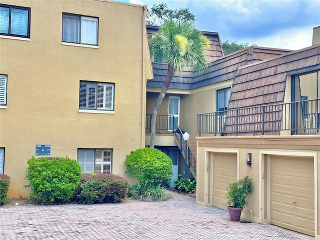 6258 Masters Blvd Unit C204, Orlando, FL 32819 - view of property with a garage, decorative driveway, and stairs