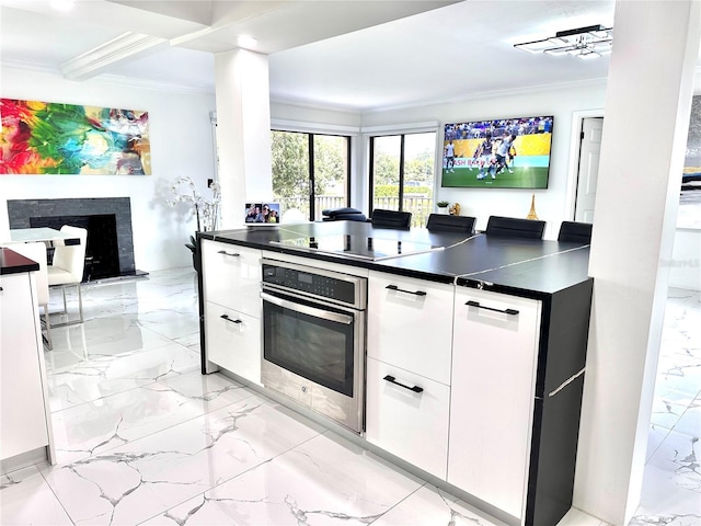 6258 Masters Blvd Unit C204, Orlando, FL 32819 - kitchen featuring oven, ornamental molding, black electric stovetop, light marble finish floors, and dark countertops