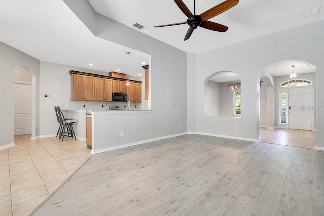 274 Wekiva Pointe Cir, Apopka, FL 32712 - unfurnished living room with arched walkways, a ceiling fan, a chandelier, light wood-style flooring, and recessed lighting