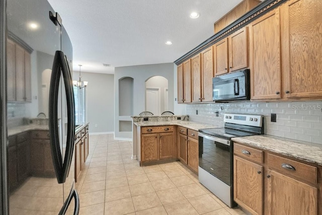 274 Wekiva Pointe Cir, Apopka, FL 32712 - kitchen featuring black appliances, tasteful backsplash, a peninsula, light tile patterned floors, and brown cabinetry