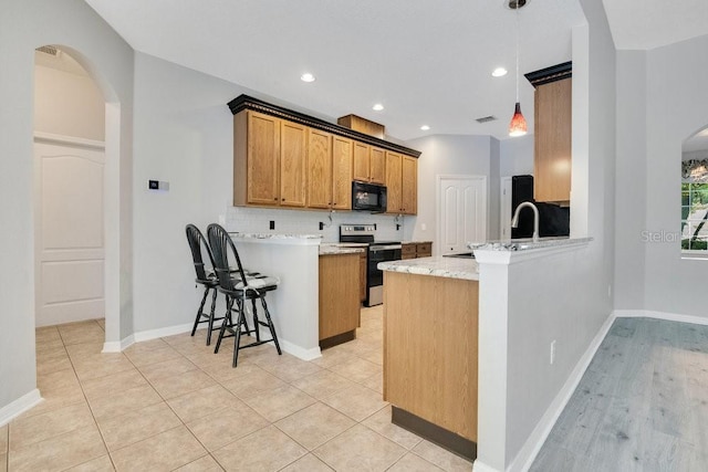 274 Wekiva Pointe Cir, Apopka, FL 32712 - kitchen featuring stainless steel electric range oven, black microwave, a peninsula, arched walkways, and decorative backsplash