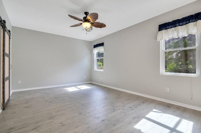 274 Wekiva Pointe Cir, Apopka, FL 32712 - unfurnished room featuring a barn door, ceiling fan, and wood finished floors