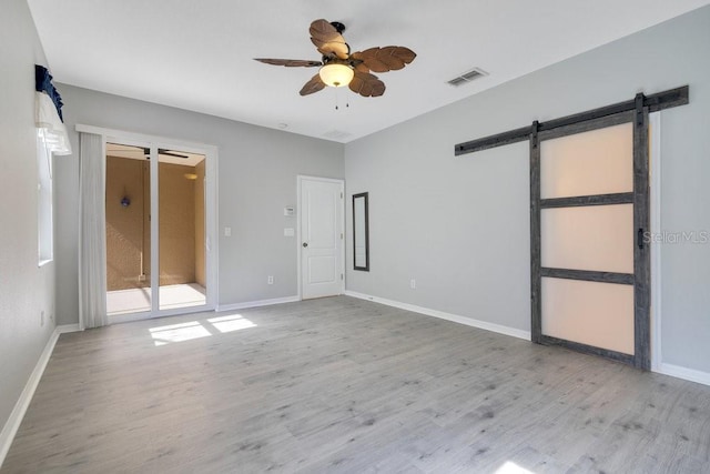 274 Wekiva Pointe Cir, Apopka, FL 32712 - unfurnished bedroom with a barn door, wood finished floors, and a ceiling fan