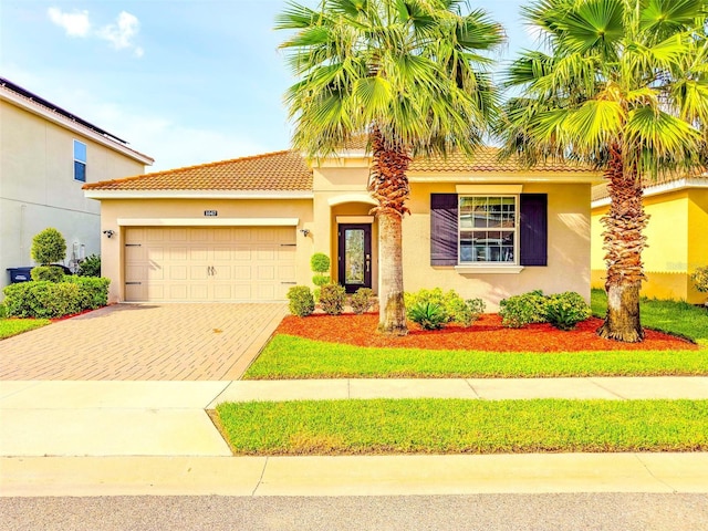 1047 Oak Bluff Dr, Davenport, FL 33837 - view of front of house with decorative driveway, stucco siding, a garage, and a tiled roof