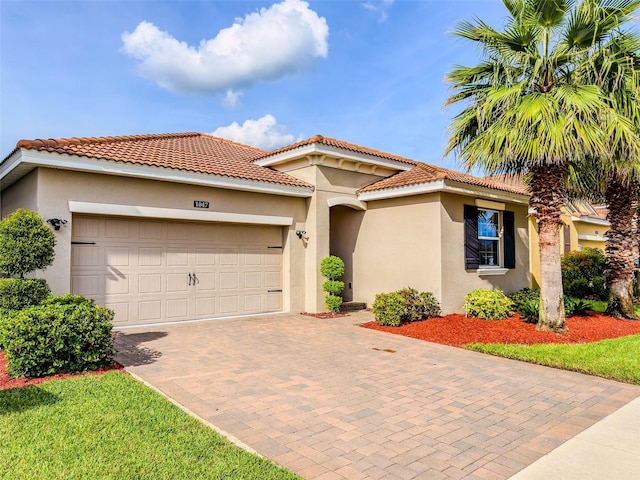 1047 Oak Bluff Dr, Davenport, FL 33837 - mediterranean / spanish house featuring stucco siding, decorative driveway, an attached garage, and a tiled roof