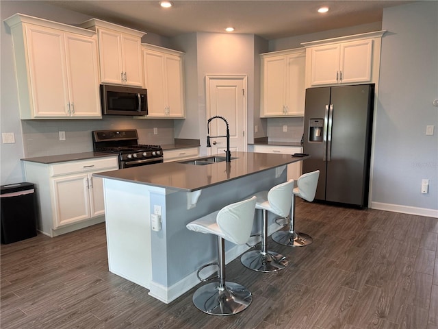 1047 Oak Bluff Dr, Davenport, FL 33837 - kitchen featuring appliances with stainless steel finishes, dark wood finished floors, white cabinets, an island with sink, and recessed lighting